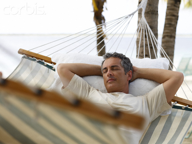 Man Relaxing in Hammock on Beach Man Relaxing in Hammock on Beach